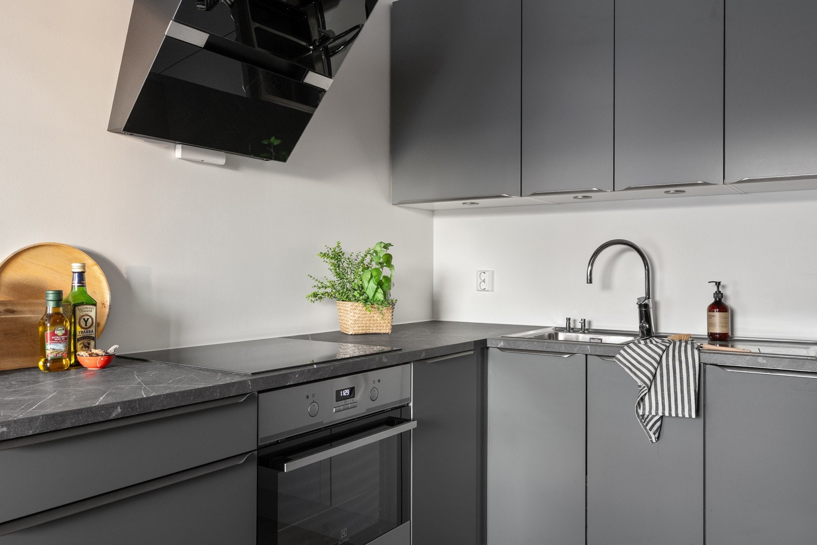 Stilfullt kjøkken med slette fronter og integrerte hvitevarer.