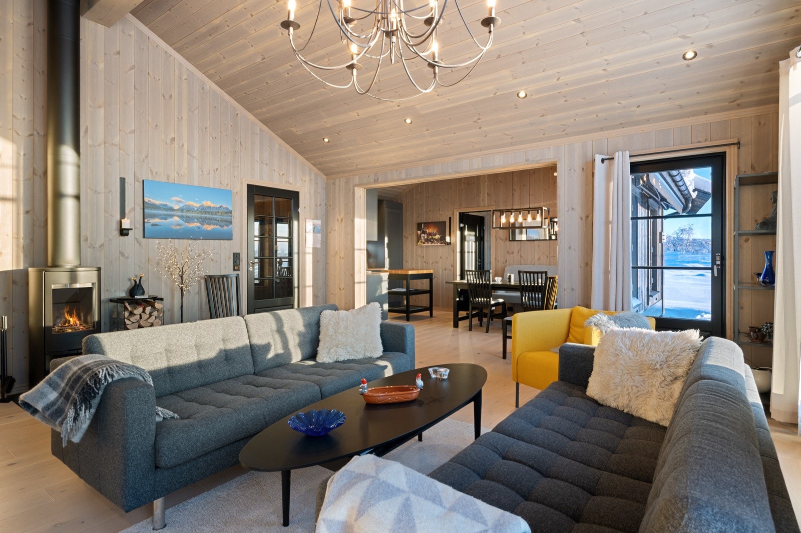 Rommet fremstår som hyttas naturlige samlingspunkt, med en lun og hyggelig atmosfære Galleribilde