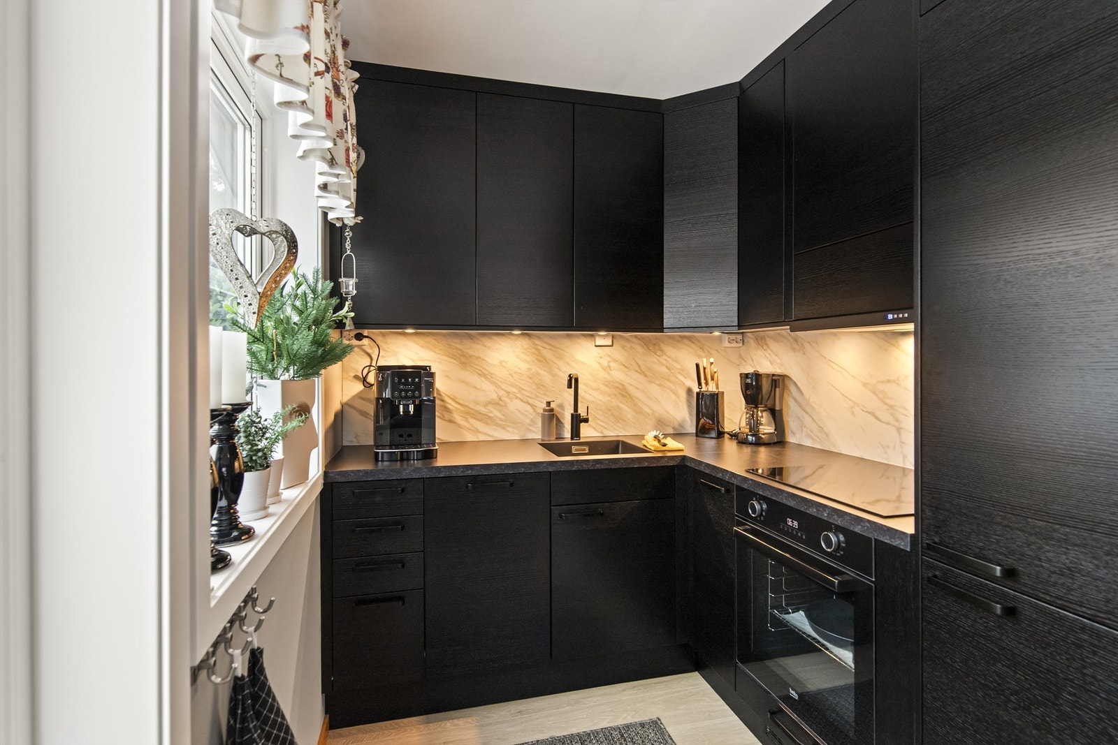 Lekkert og tidløst Epoq kjøkken med integrerte hvitevarer og splashboard på vegg Galleribilde