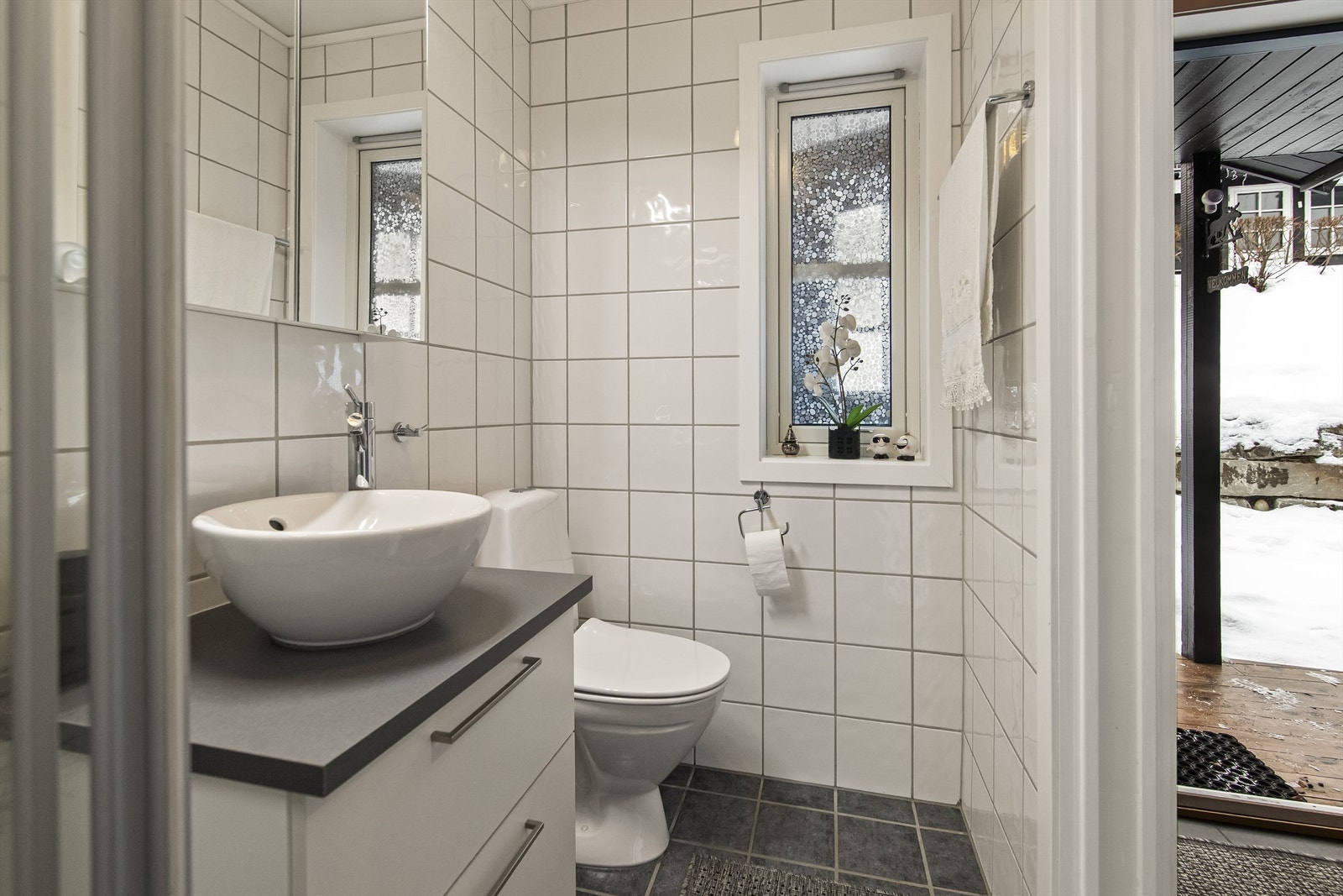 Badet er innredet med toalett, dusjhjørne og servant i innredning Galleribilde