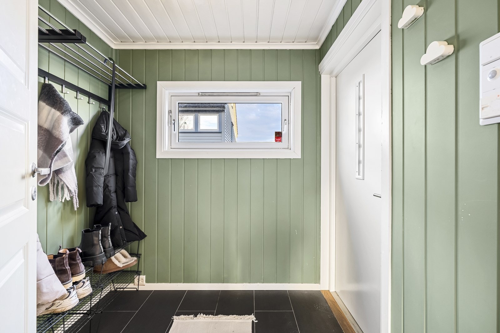 Praktisk flislagt vindfang med plass til sko og yttertøy Galleribilde
