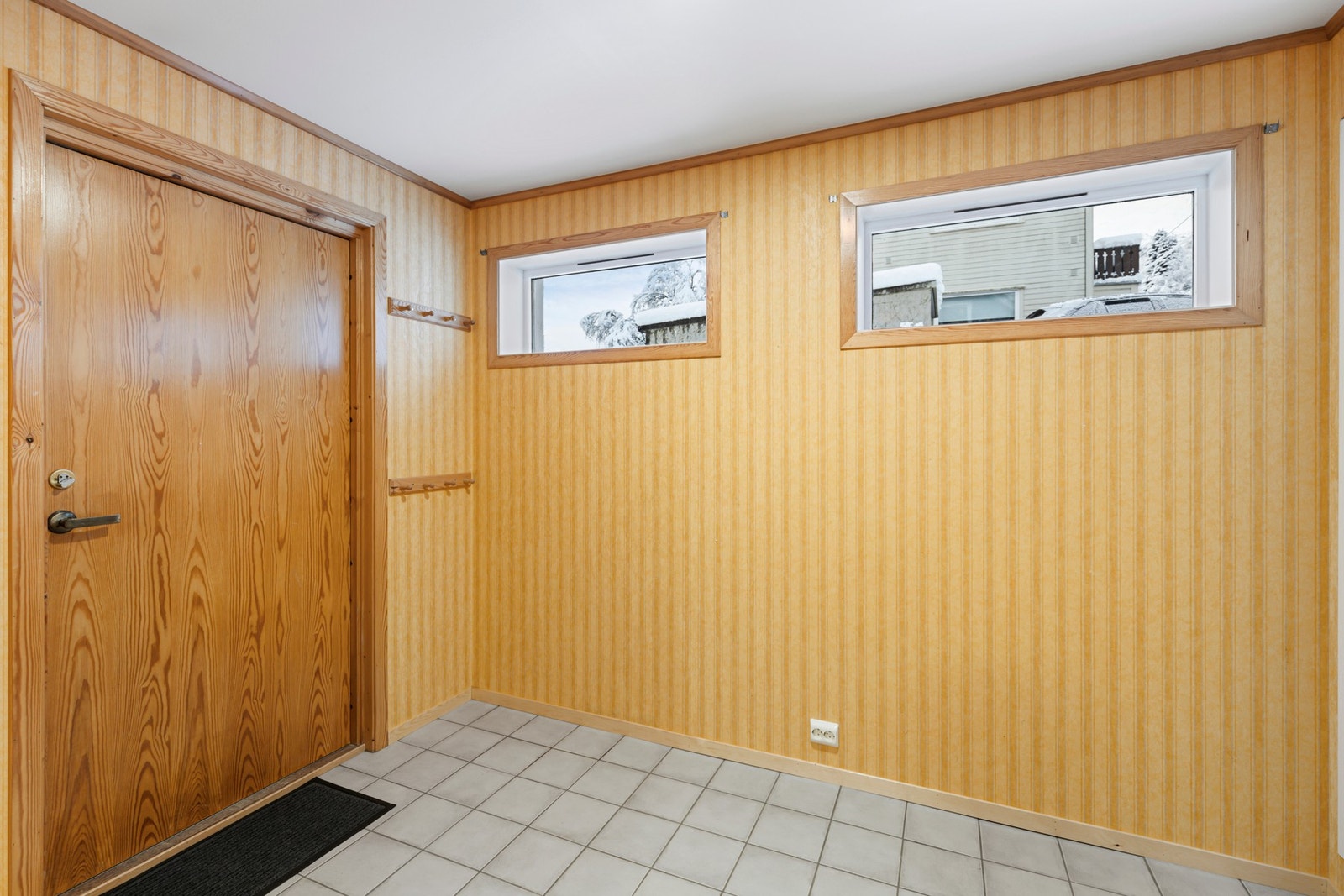 Entrèen til sokkelleiligheten ble tilbygd rundt 2001, og har flislagt gulv med gulvvarme, og garderobløsning Galleribilde