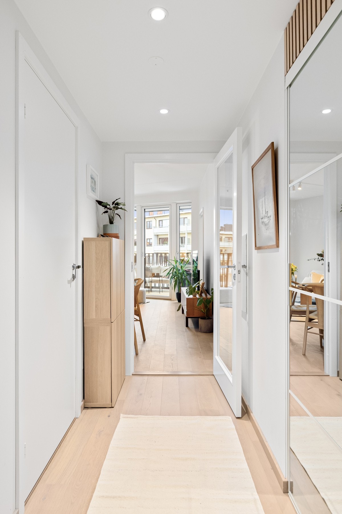 Mellom entré og stue er det en stilfull dør med glassfelt, som slipper lyset gjennom og skaper en elegant overgang mellom rommene. Galleribilde