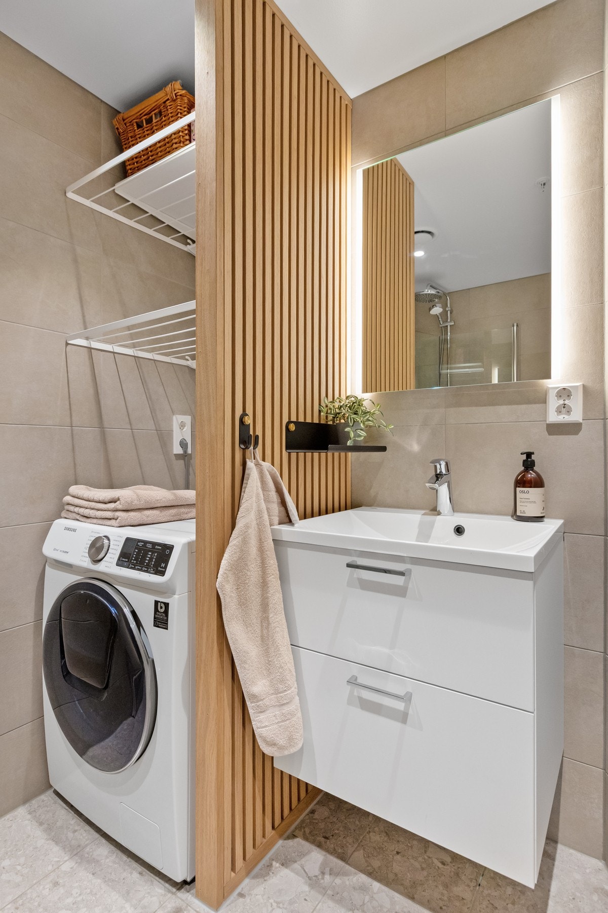 Her er det veggfestet toalett og opplegg for vaskemaskin - funksjonelt og stilrent. Galleribilde