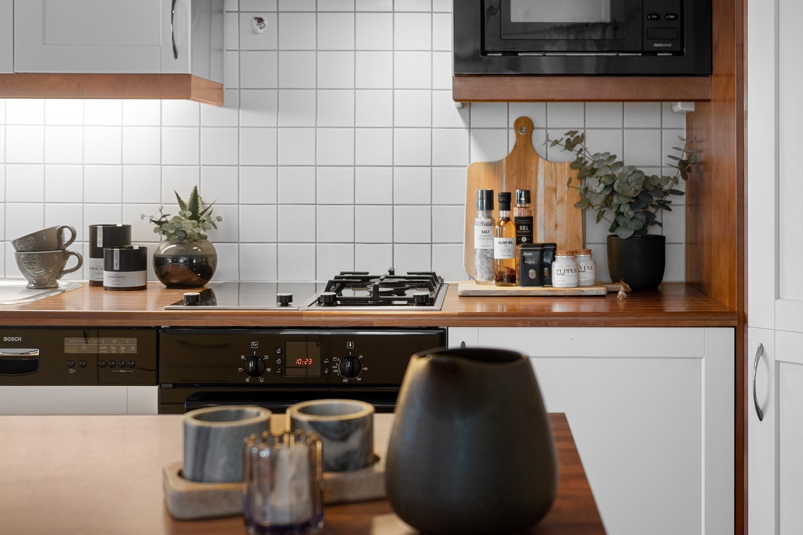 Det er fliser på veggen mellom benkeplaten og overskapene. Galleribilde