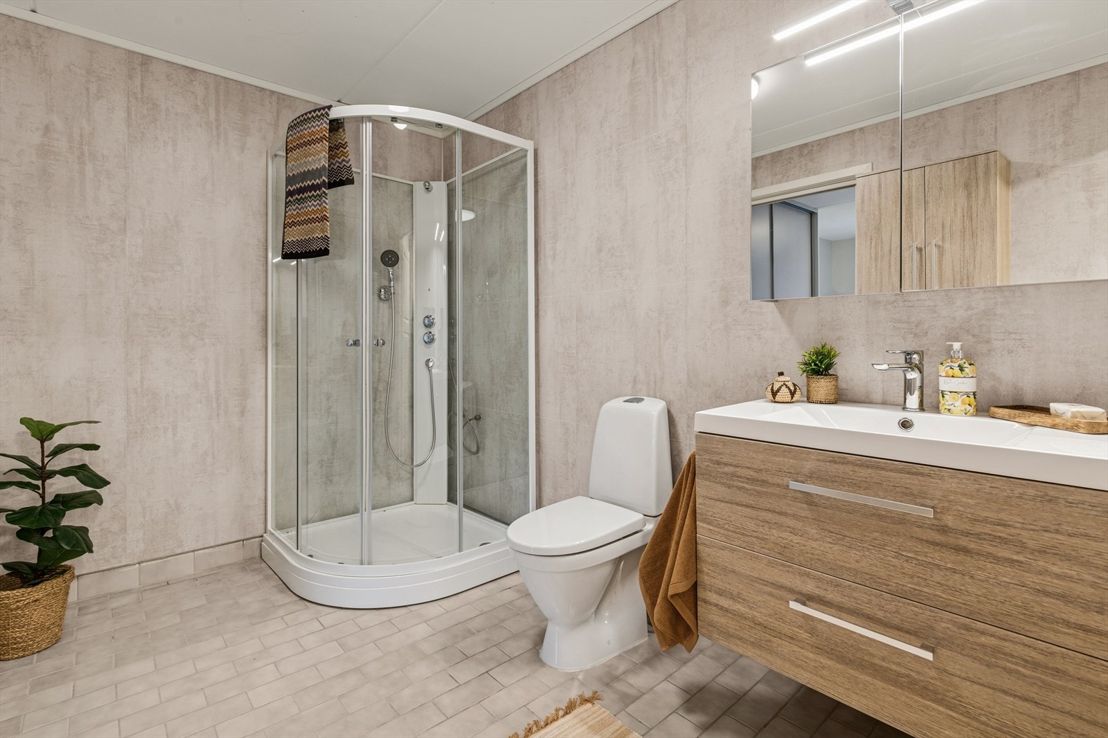 Flislagt med varme i gulvet, baderomsplater på vegger og innredet med nyere baderomsmøbler. Badet er i hovedsak fra byggeåret og det anbefales fortsatt bruk av dusjkabinett. Galleribilde