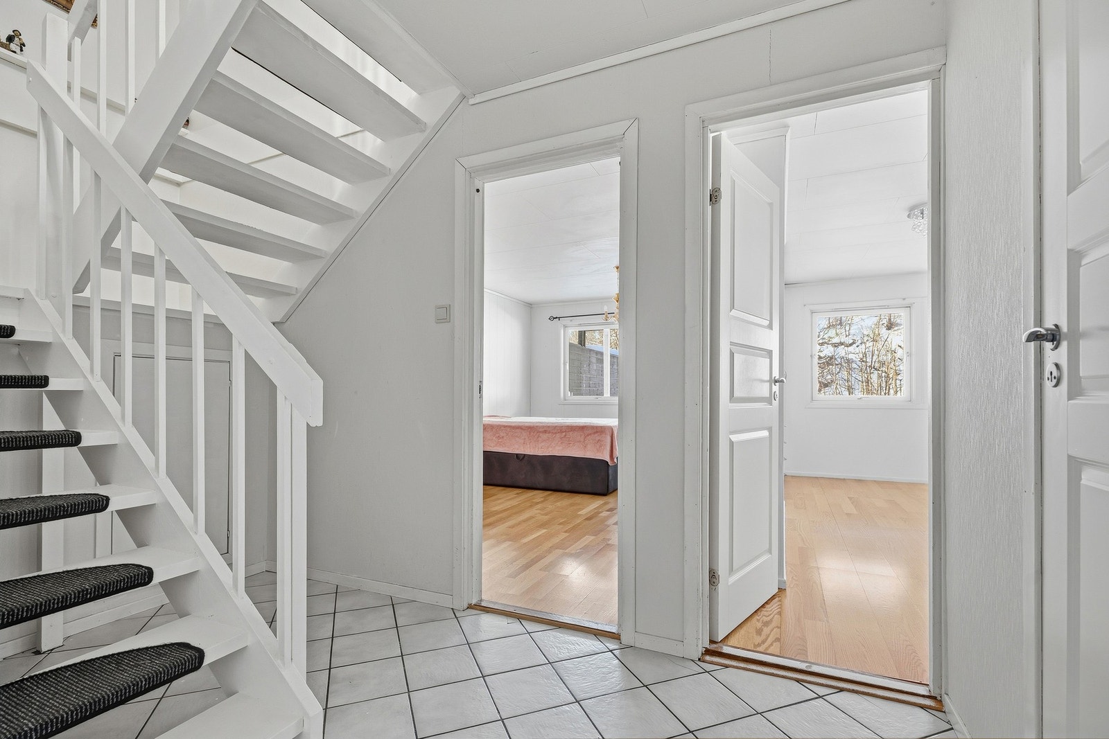 Flislagt gang i underetasjen. Her er det lagringsplass i kott under trappen Galleribilde