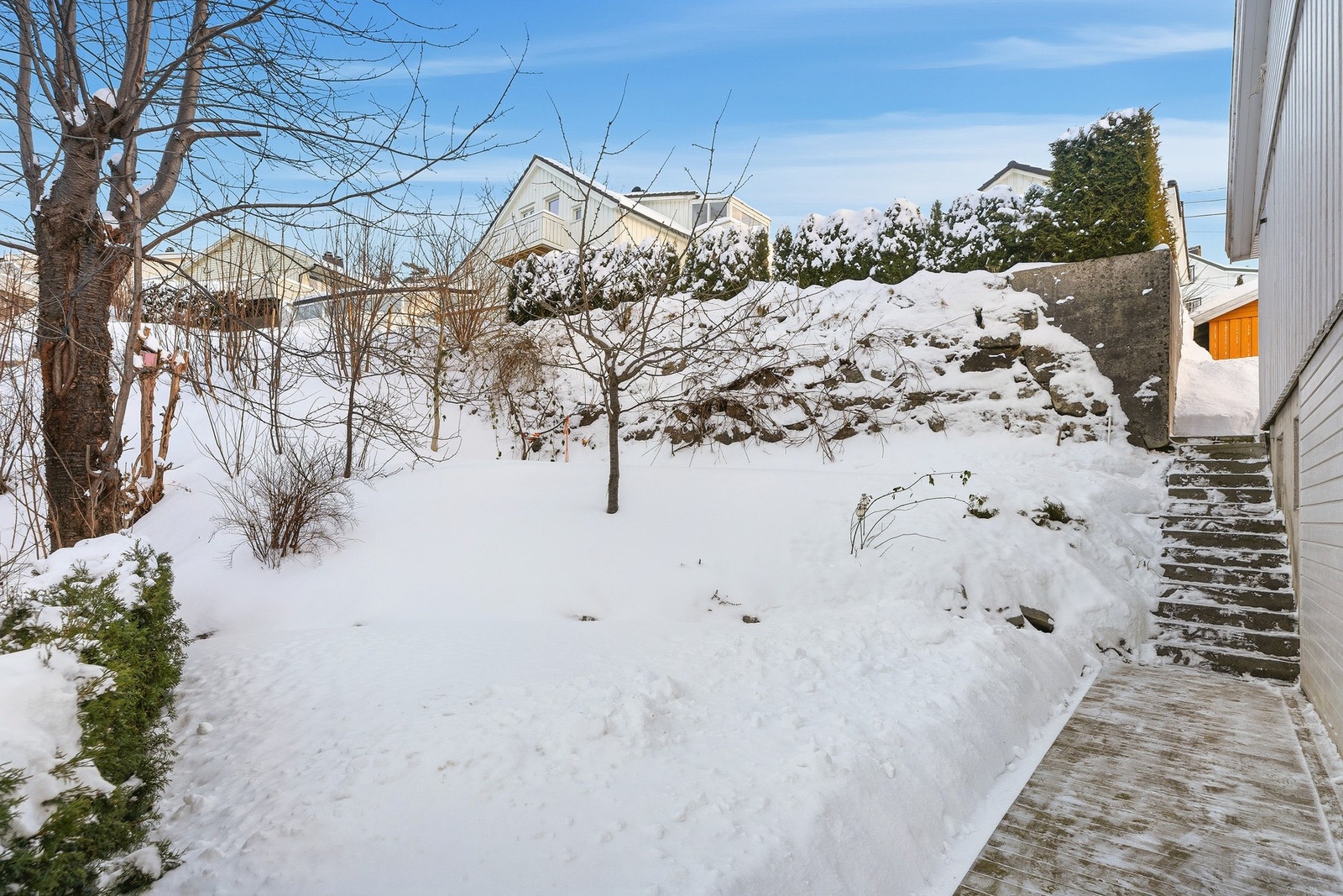 Rundt boligen er det en hyggelig hage med planter og frukttrær, godt skjult under snøen Galleribilde