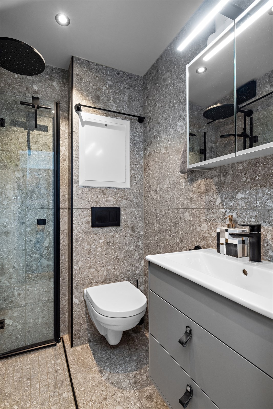 Badet er helfliset med moderne innredning og en romslig dusjnisje. Galleribilde