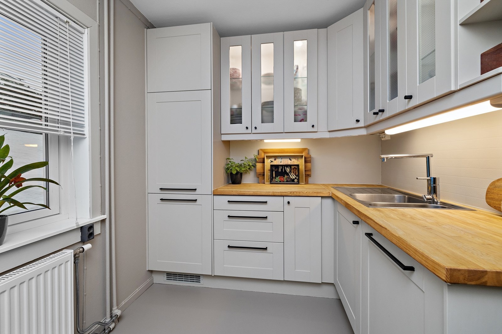 Vitrineskap med belysning gir en fin detalj og ekstra oppbevaringsplass. Galleribilde