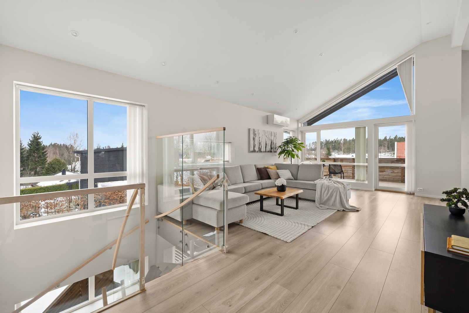 Lys og moderne stue med store vindusflater og over 4 meter takhøyde som gir en imponerende romfølelse og rikelig med naturlig lys Galleribilde