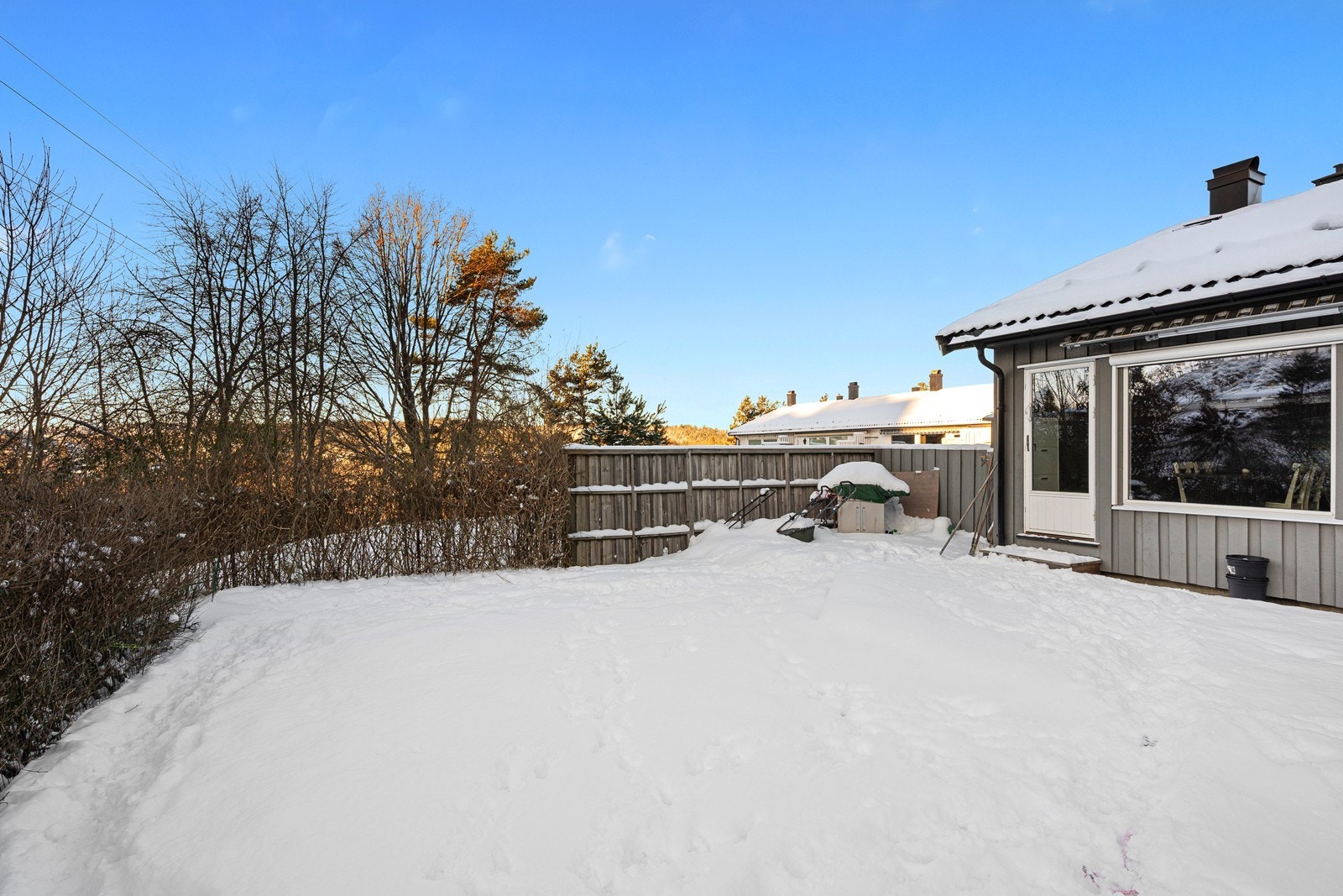 Koselig uteplass med terrasse (2021) og gressplen. Galleribilde