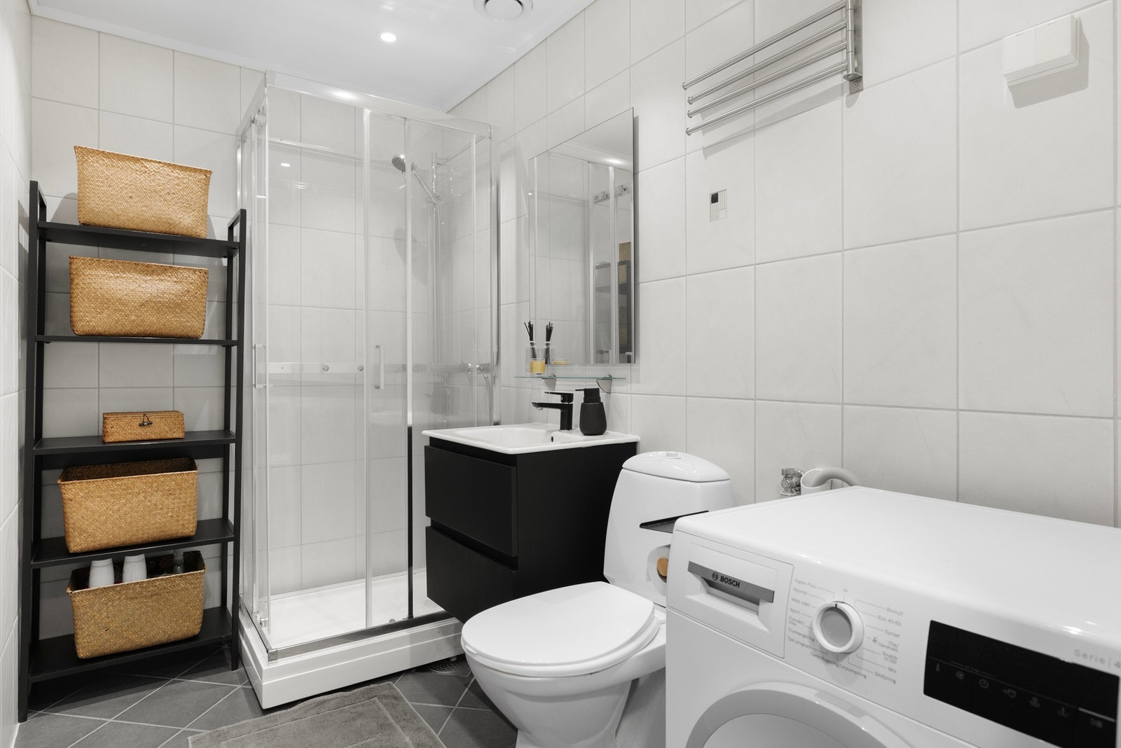 Et lyst og pent bad med flislagte overflater og komfortabel gulvvarme. Galleribilde