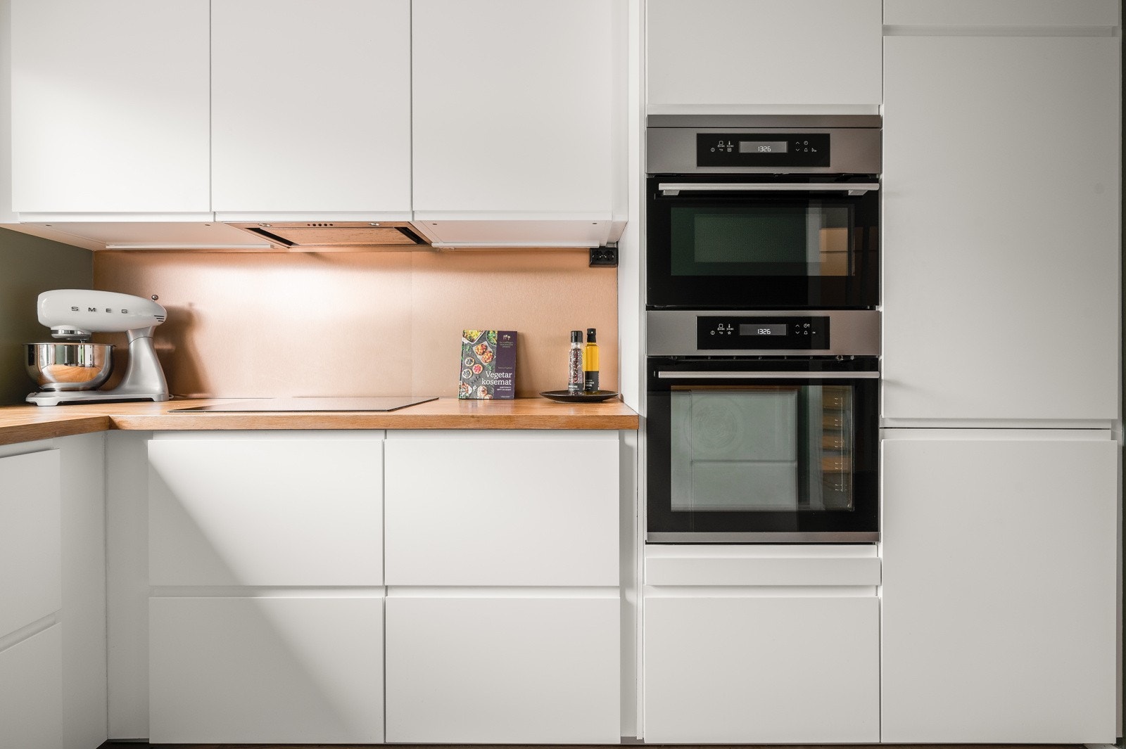 Lyse skapfronter og innfelte hvitevarer gir kjøkkenet et stilrent utseende. Galleribilde