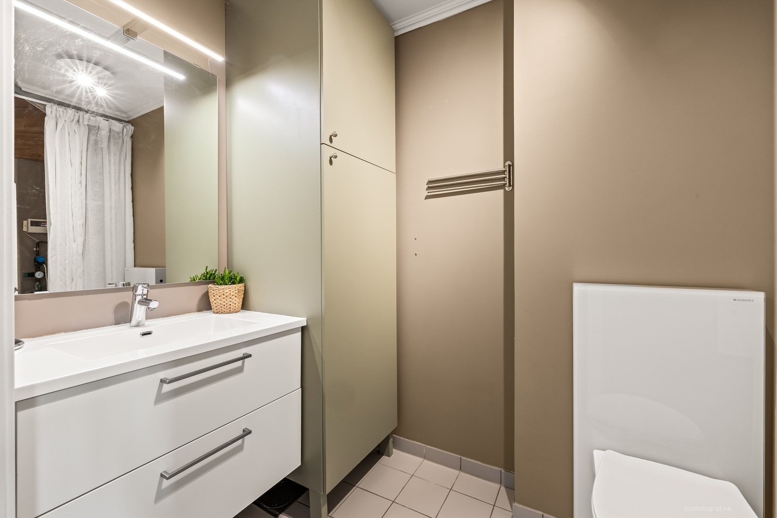 Praktisk bad/vaskerom i 1. etg. med varmekabler i gulv, vegghengt toalett og baderomsinnredning med servant. Galleribilde