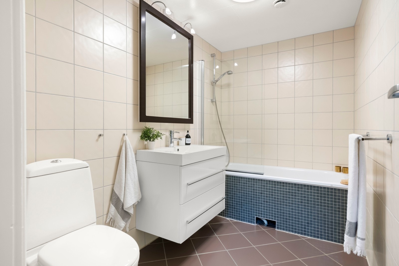 Innbydende bad fra 2007 med fliser og varmekabler under. Rommet er innredet med et innebygd badekar med dusjløsning, toalett og lys baderomsinnrending. Mekanisk avtrekk her også. Galleribilde