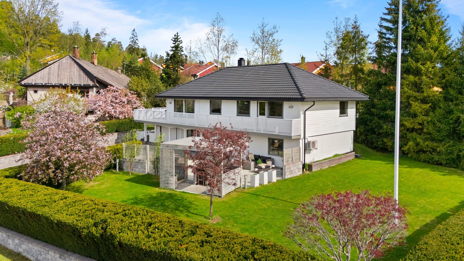 Den store gressplenen gir godt med boltreplass for både små og store, og er omkranset av ulike beplantninger som tilfører liv og farge til hagen gjennom sesongen. Galleribilde