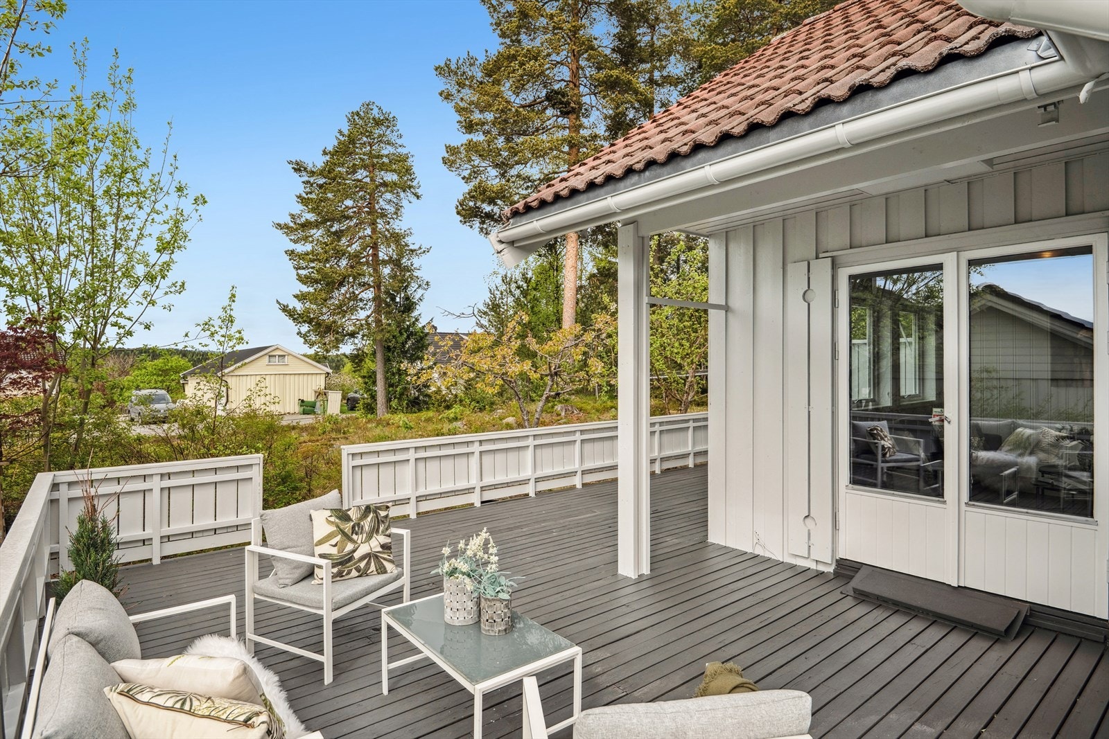 En stor og solrik terrasse med plass til utemøbler og grill. Galleribilde