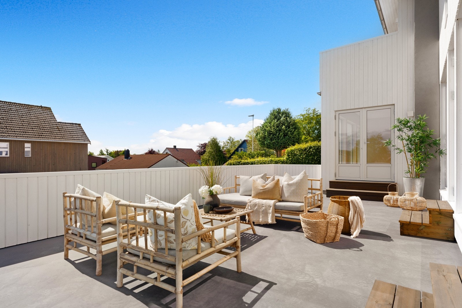 Terrassen har slipt betong på dekket og tett, hvitmalt rekkverk i tre. Galleribilde