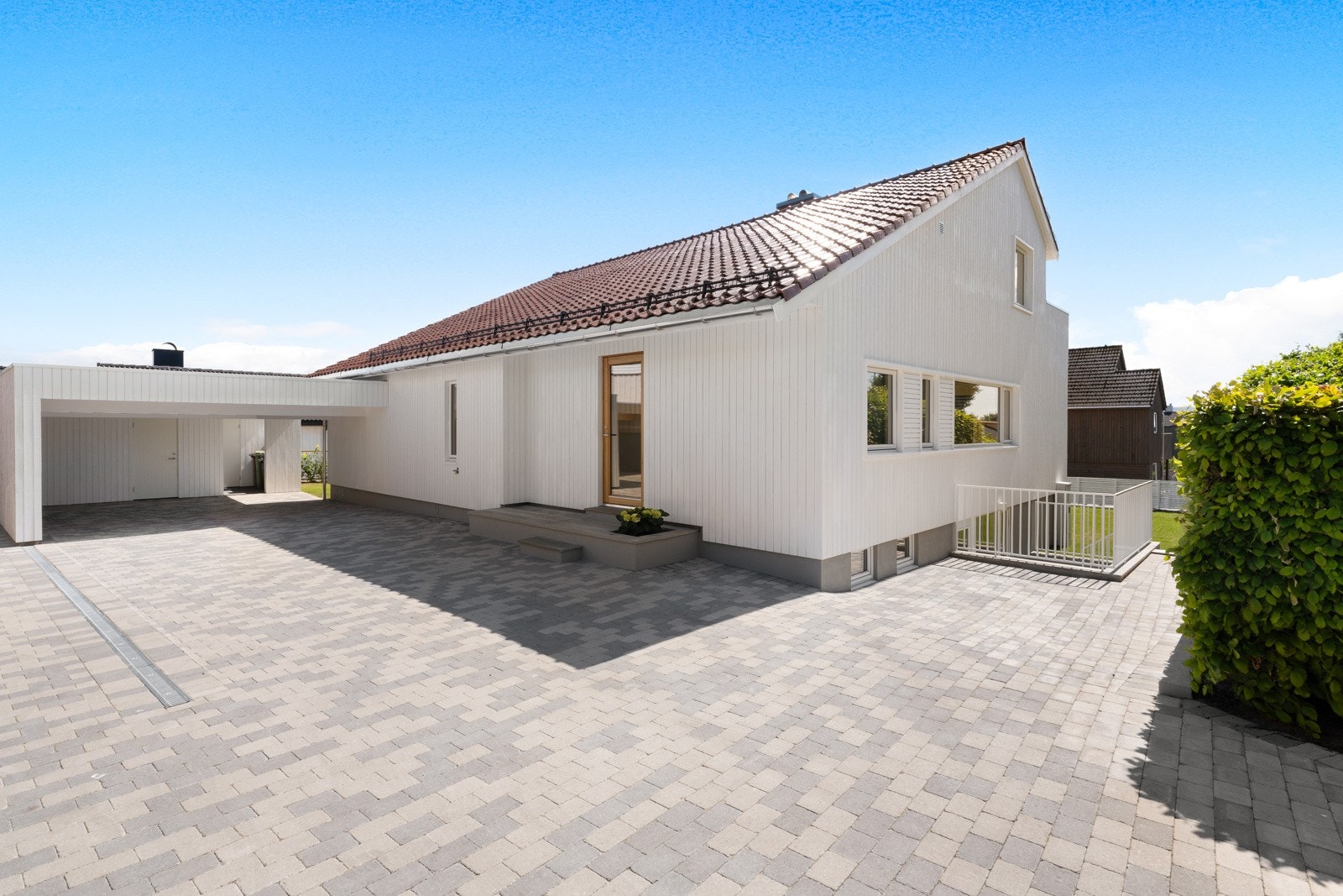 Gårdsrommet er steinbelagt og har dobbel carport og plass til parkering for flere biler. Galleribilde