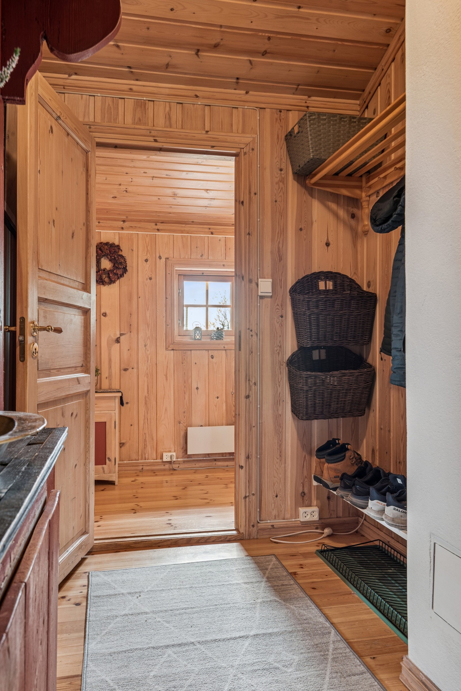 Videre kommer du inn i hytta sin gang med garderobeplass Galleribilde