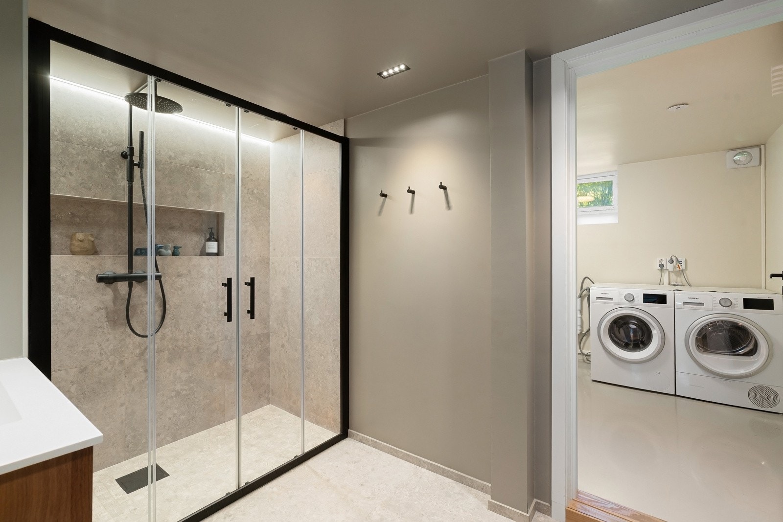 Utstyrt med regnfallsdusj og hånddusj, nedfelt servant på dobbel skuffeseksjon, downlights og gulvvarme. Galleribilde