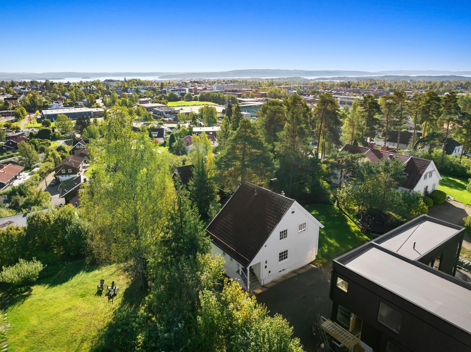 Tomten er pent opparbeidet og har fine grenser mot omkringliggende naboer - To biloppstillingsplasser med én elbillader. Galleribilde