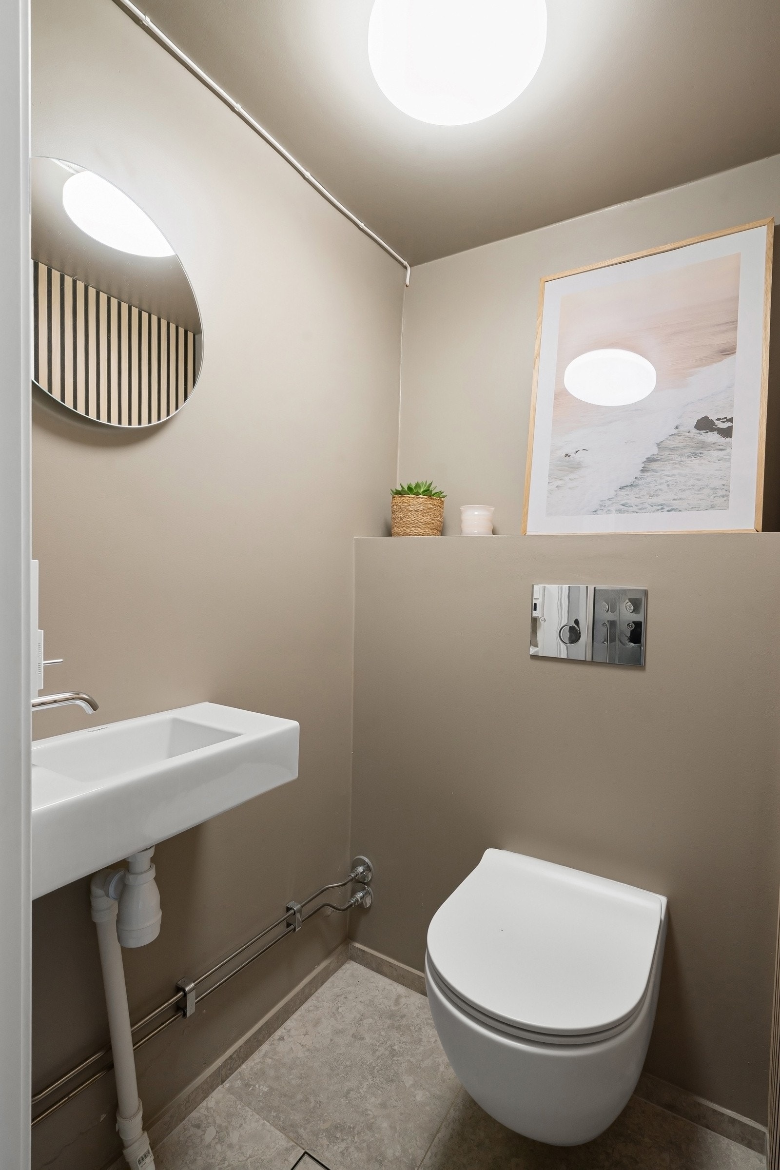 Toalettrom fra 2022 i tilknytning til underetasjen, utstyrt med vegghengt klosett og servant. Galleribilde