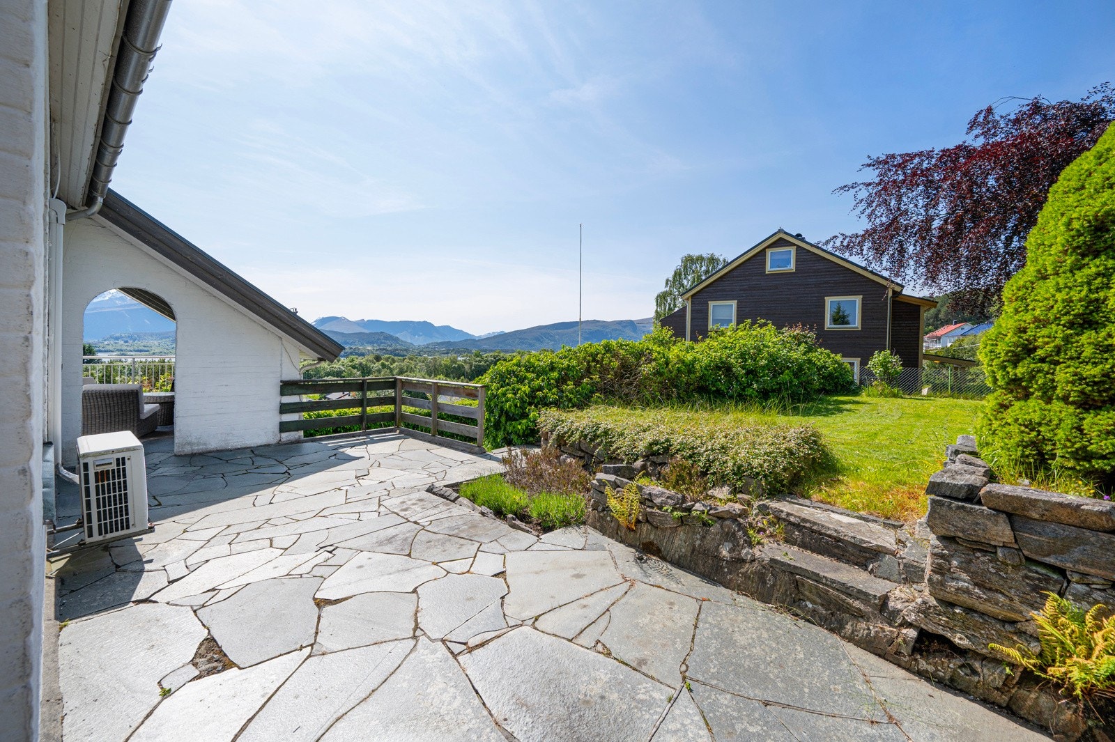Bak hagestuen er også en stor og fin terrasse med skifer. Her sitter man lunt og skjermet. Galleribilde