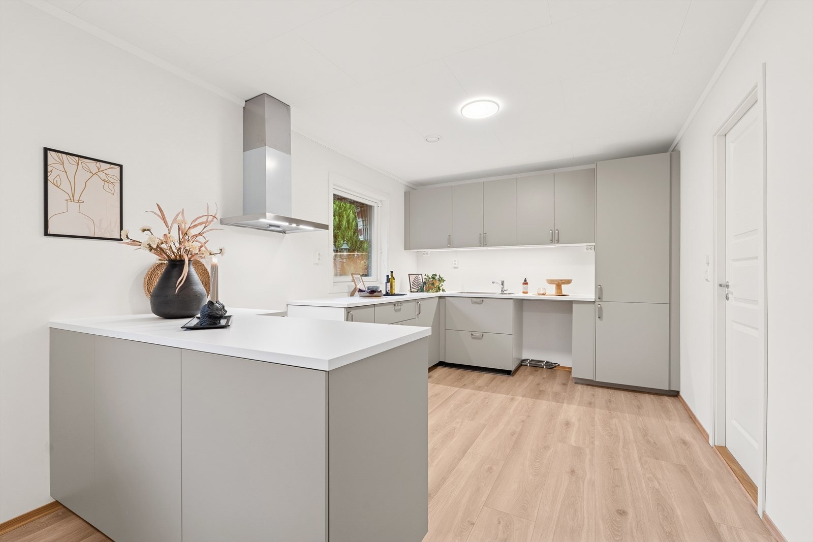 Ventilator over stekeovn og ventil i himling sikrer god ventilasjon på kjøkkenet. Galleribilde