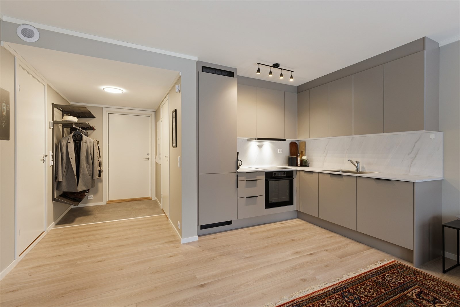 Stilrent og moderne kjøkken med grå slette fronter og lys benkeplate. Galleribilde