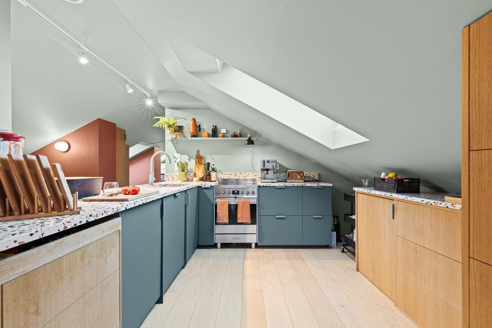 Innredningen har en stilig farge- og materialkombinasjon og består skap med innslag av eik og benkeplate i elegant Nero-stein Galleribilde