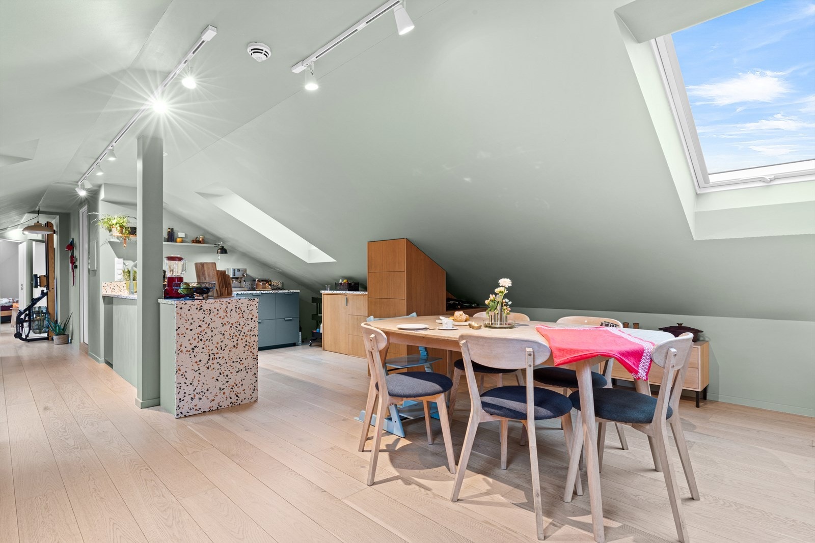 Planløsningen gir gode muligheter for naturlig inndeling i soner for både sofagruppe og spiseplass, og rommet byr på flere smarte og integrerte oppbevaringsløsninger. Galleribilde