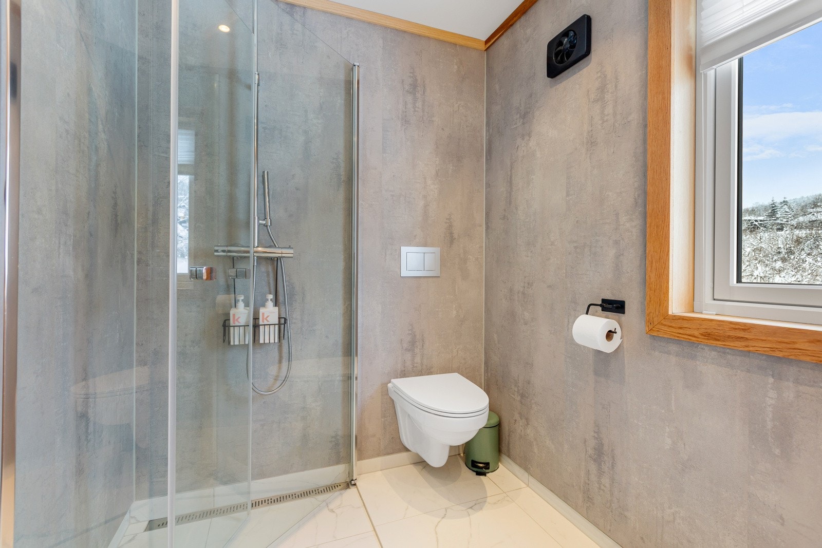 Innredningen består av servant med underskap, speil med belysning, dusjvegger og vegghengt toalett. Galleribilde