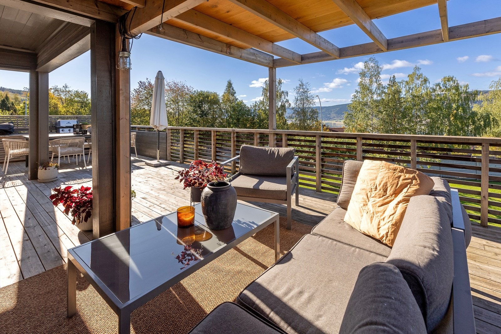 Utsikt fra terrasse med treverk, ideell for solfylte dager. Galleribilde