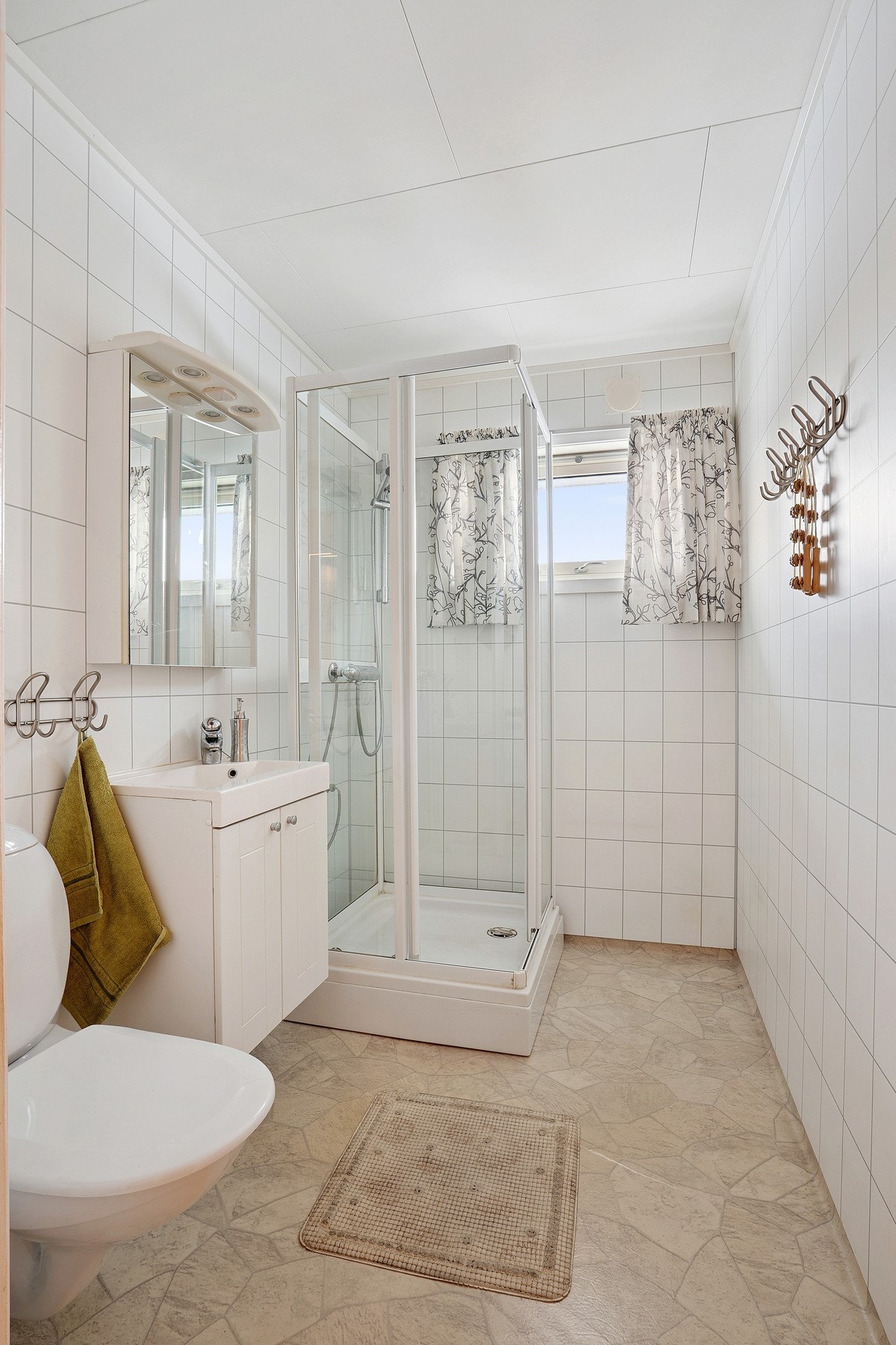 Baderomsinnredning med nedfelt servant, speilskap, veggmontert toalett og dusjkabinett Galleribilde