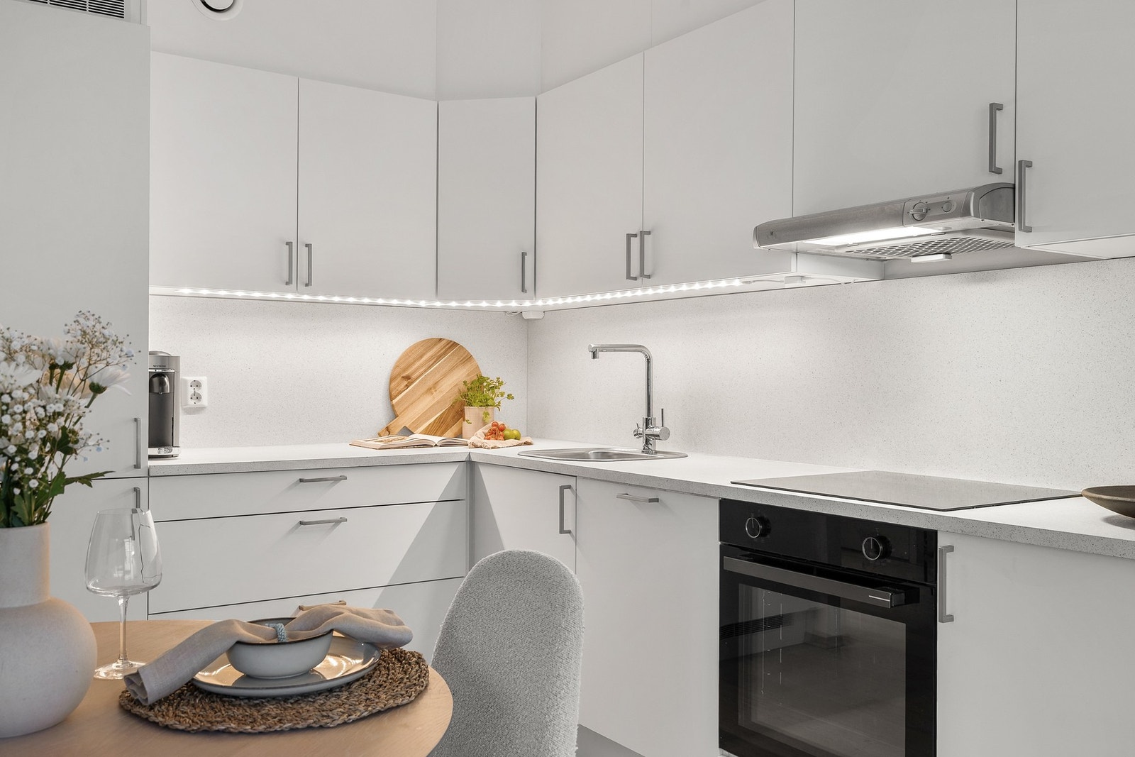 Kjøkkenet er utstyrt med nedsenket oppvaskkum i stål, induksjonstopp og integrerte hvitevarer, herunder stekeovn, oppvaskmaskin og kjøl/frys Galleribilde