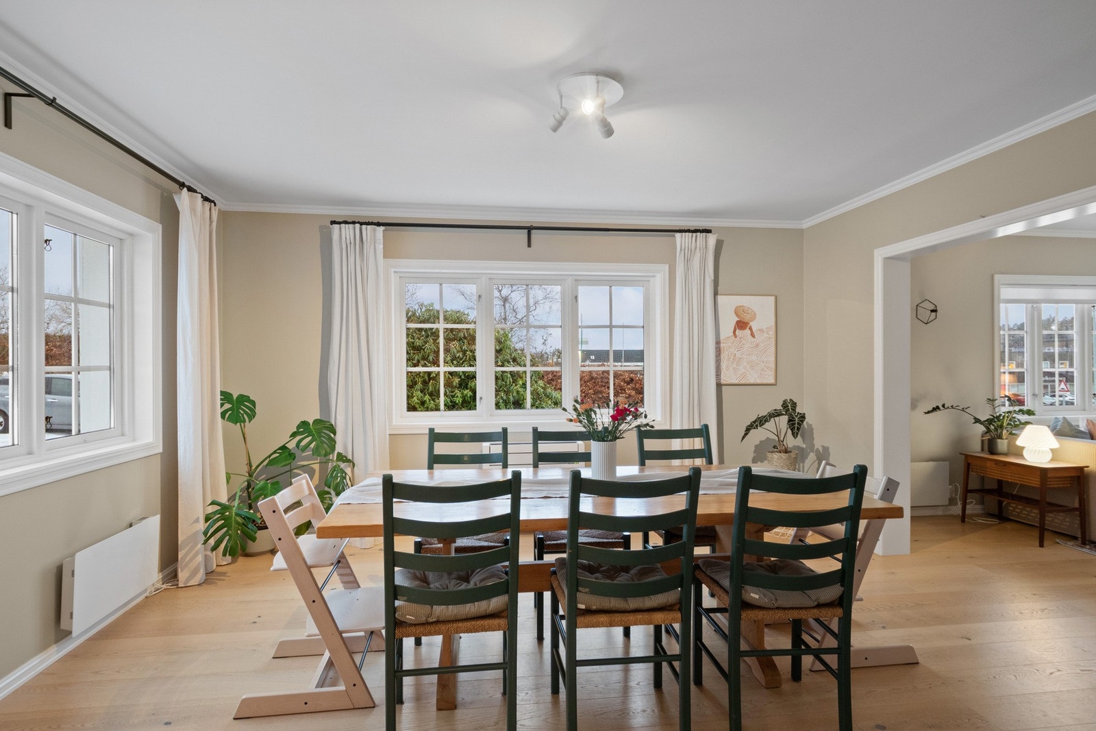 En spisestue i beige toner med mange vinduer oppleves som lys, rolig og svært innbydende. Galleribilde