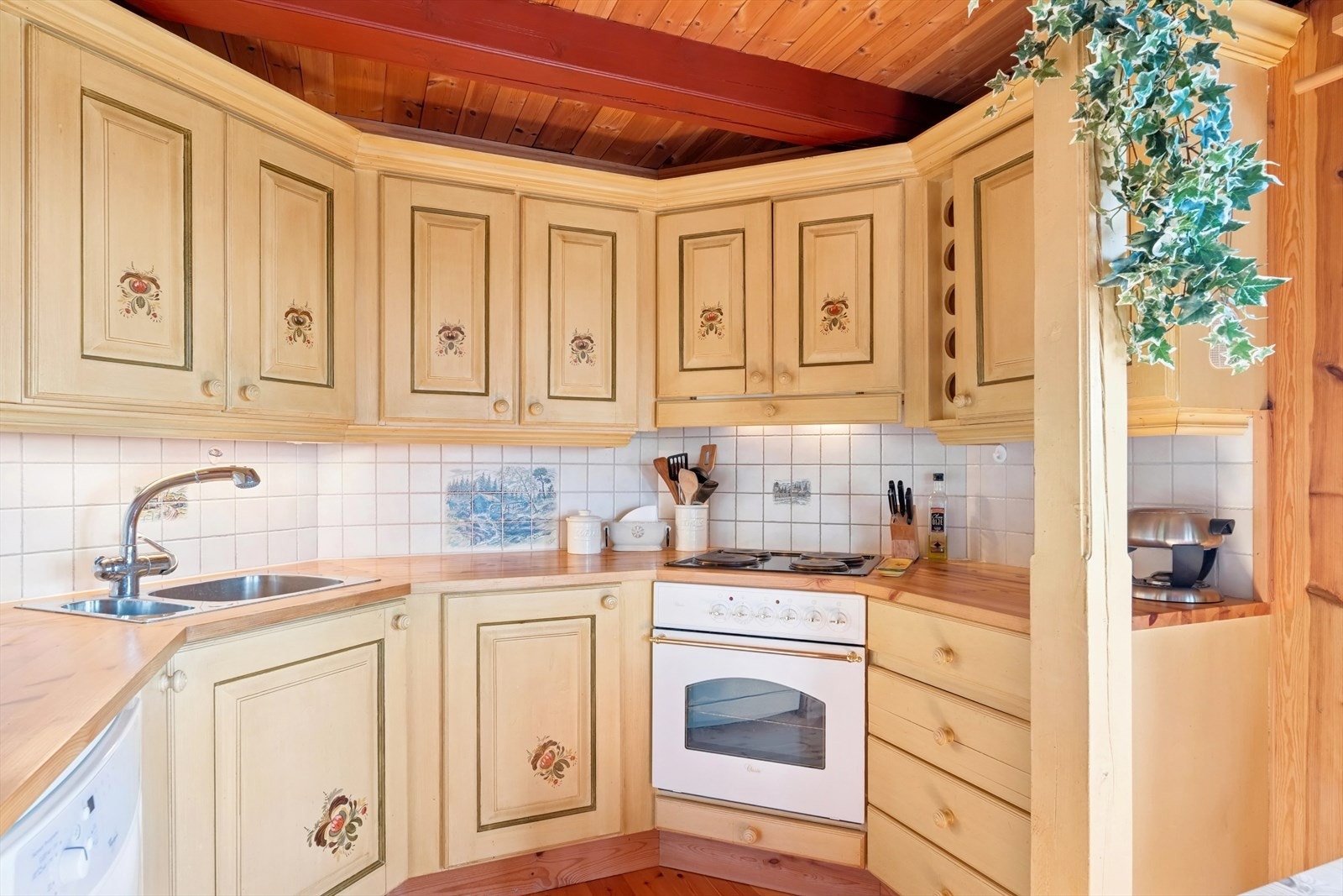 Kjøkkeninnredningen er i solid heltre med malte, profilerte fronter og heltre benkeplate med nedfelt kjøkkenkum. Galleribilde