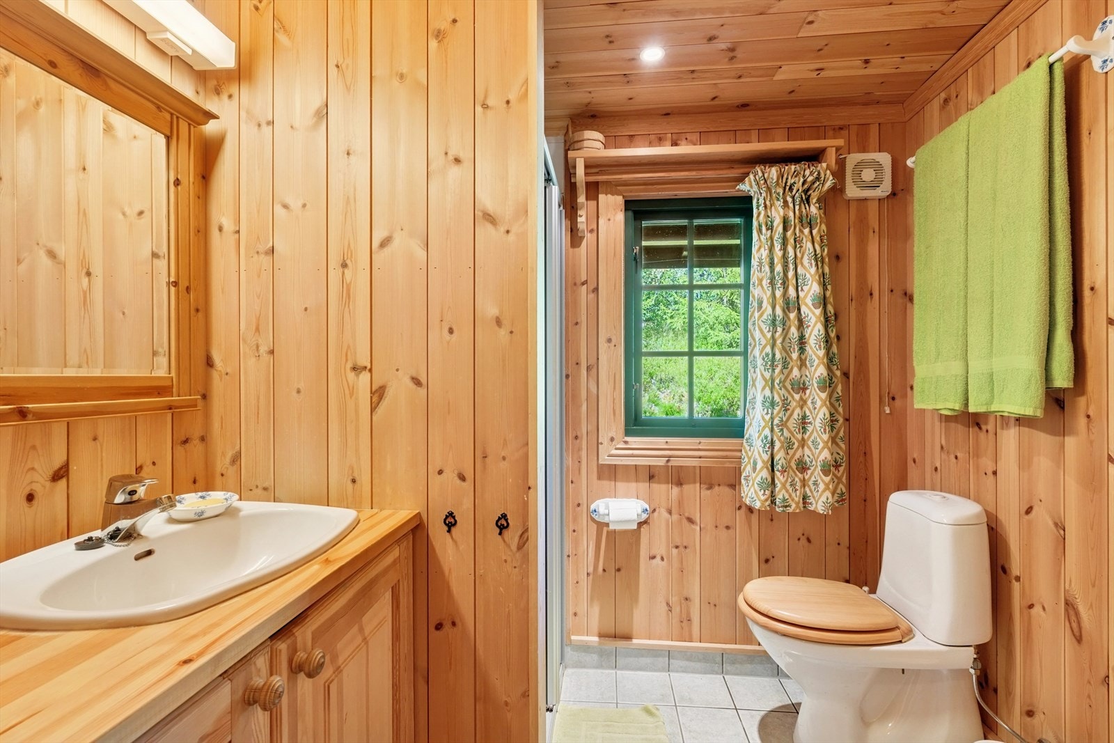 Badet er fra byggeåret, med panel på veggene og fliser på gulvet med varmekabler. Galleribilde