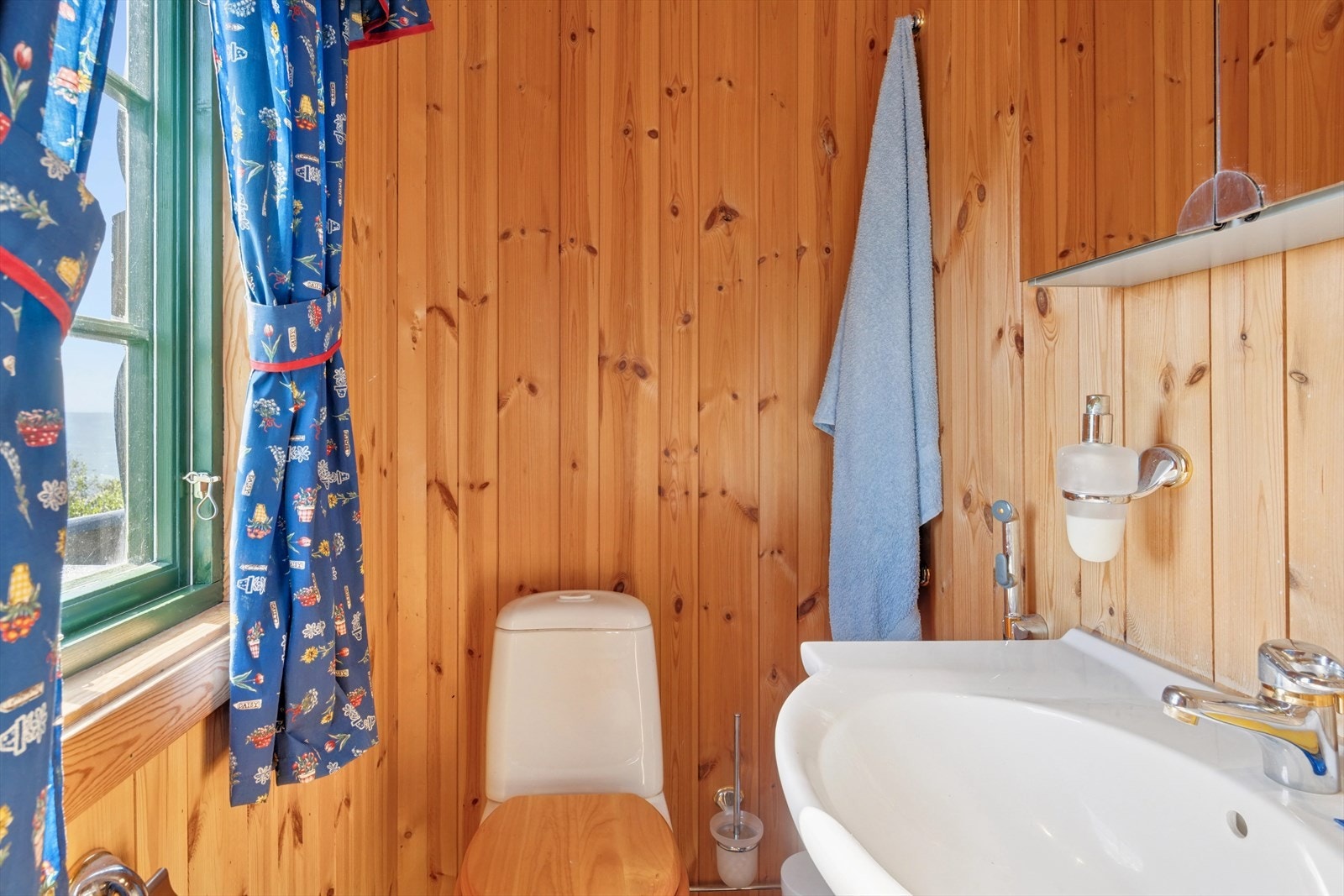 Hytten har et praktisk toalettrom med tilgang fra det ene soverommet, innredet med gulvmontert toalett og servant. Galleribilde