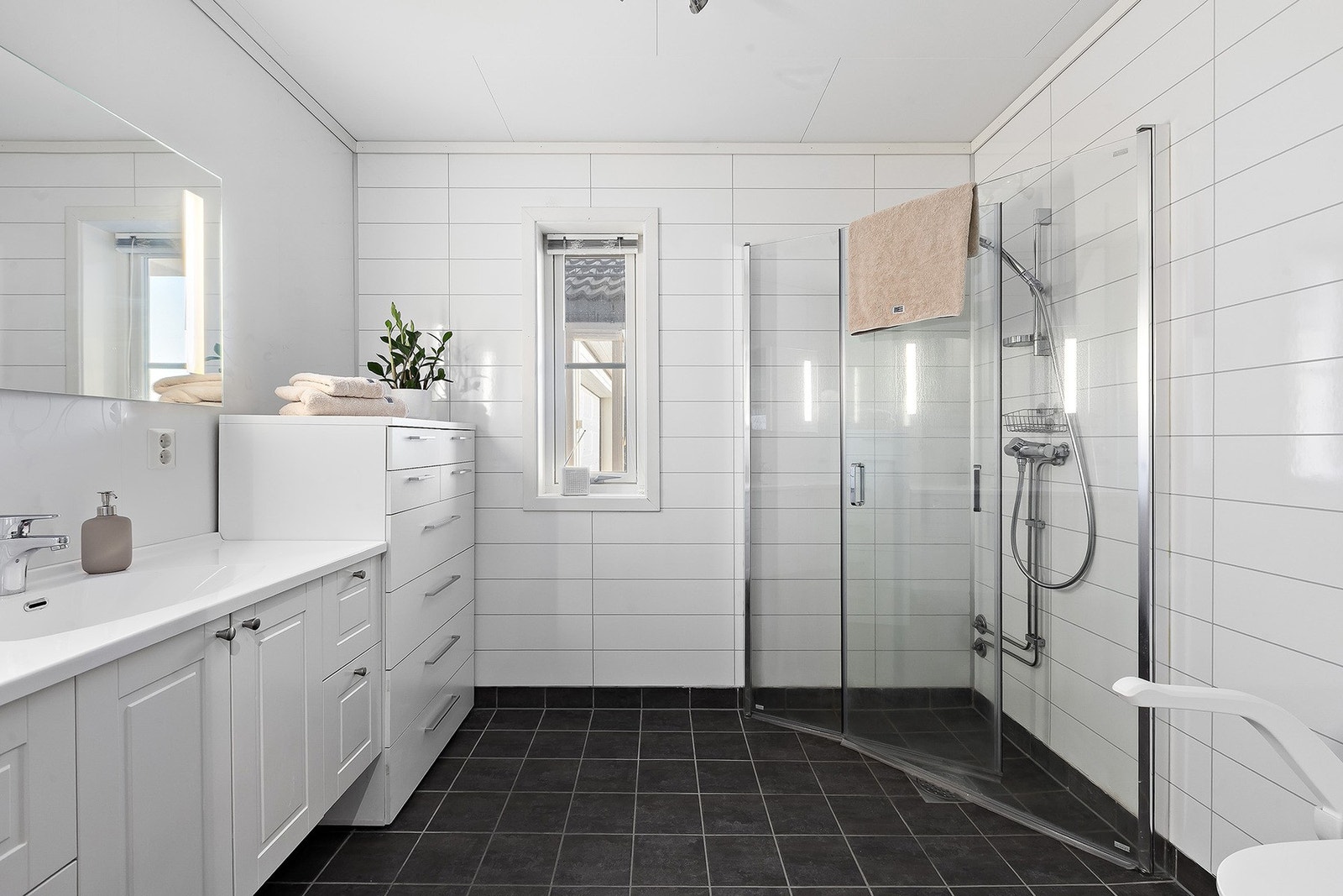 Romslig bad med mye skapplass. Veggene har baderomspanel og gulvet er flislagt med gulvvarme. Galleribilde