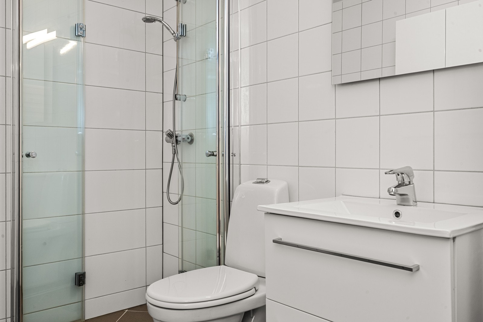 Dusjhjørnet har glassdører som kan slås inn mot veggen for å frigjøre gulvplass. Galleribilde