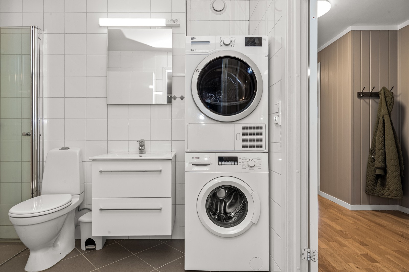 Helfliset bad med opplegg for vaskesøyle, som gir en praktisk og arealeffektiv vaskeromsdel. Galleribilde