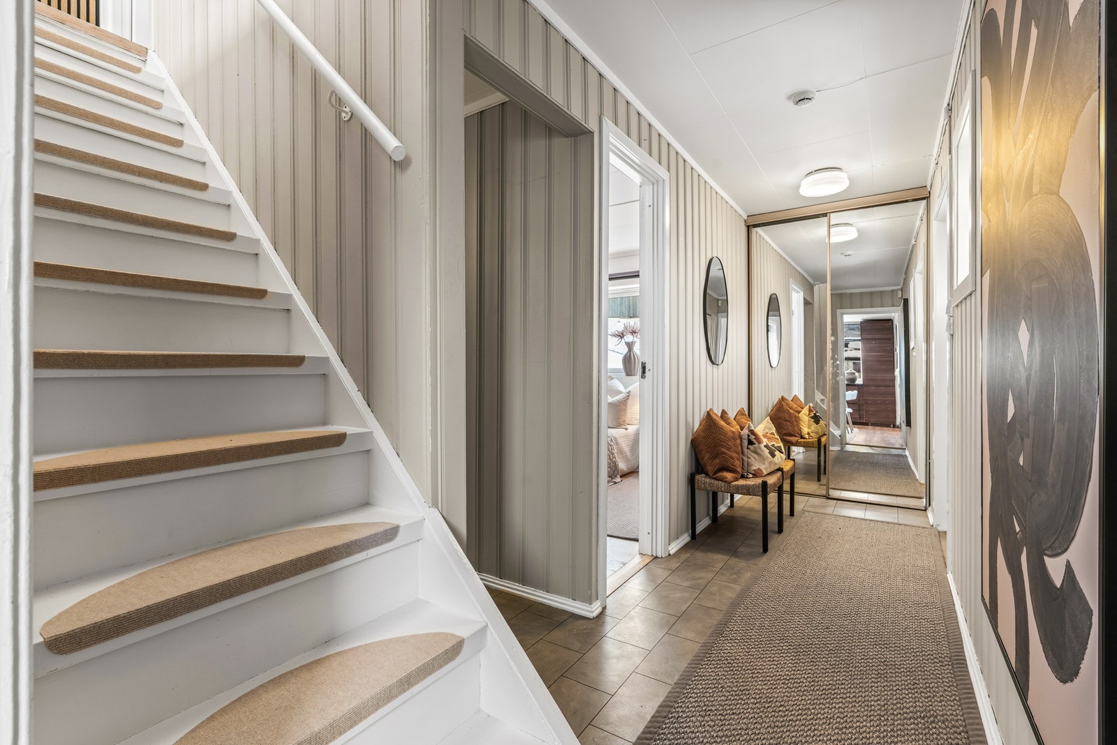 Entréen/gangen har flislignende laminat på gulv og nymalt panel på vegg malt i en harmonisk beigetone. Gangen har skyvedørsgarderobe med speilfronter for oppbevaring av yttertøy. Galleribilde