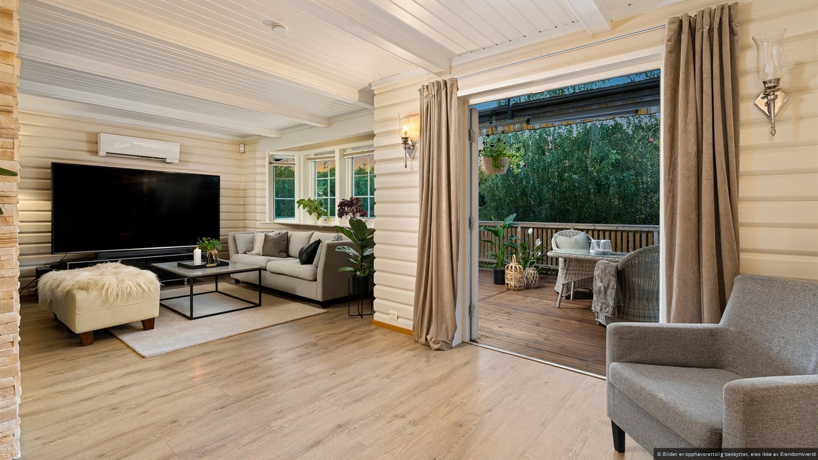 Hyggelig stue med utgang til veranda som omkranser boligen. Galleribilde