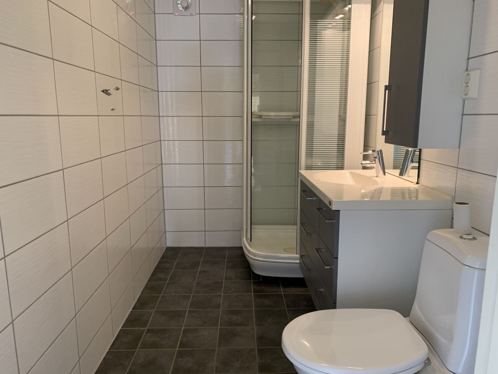 Nyere bad med fliser. Dusjkabinett og servant med innredning Galleribilde