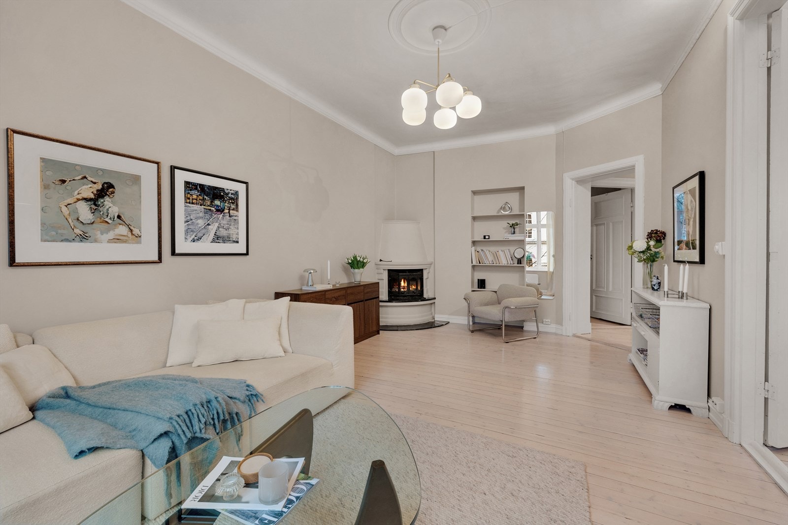 Stor åpen stue med tidsriktige farger og ildsted i hjørnet for hygge og varme. Galleribilde