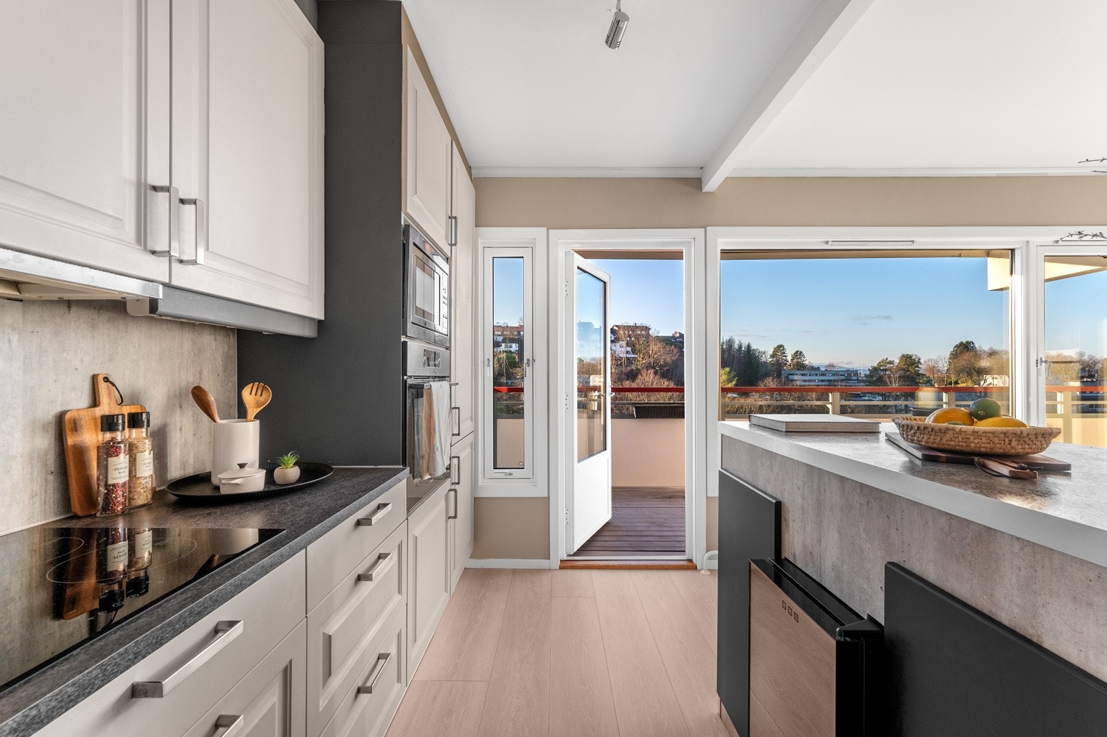 Utgangen til den 14 kvm. store sørvestvendte altanen befinner seg ved kjøkkenet. Galleribilde