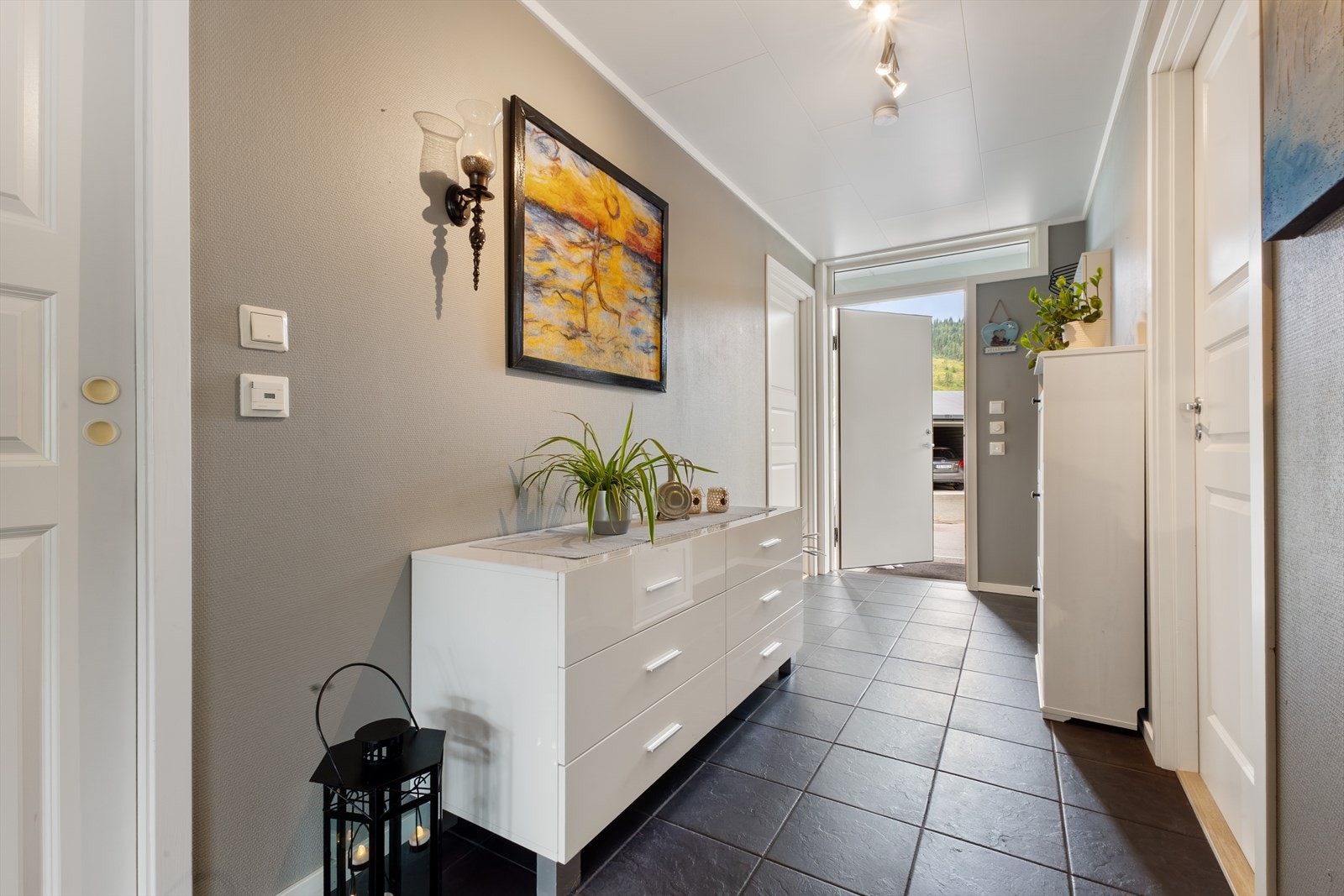 Stor entre med flislagt gulv og varmekabler. Det avlange vinduet over ytterdøren gir fin lysinngang. Galleribilde